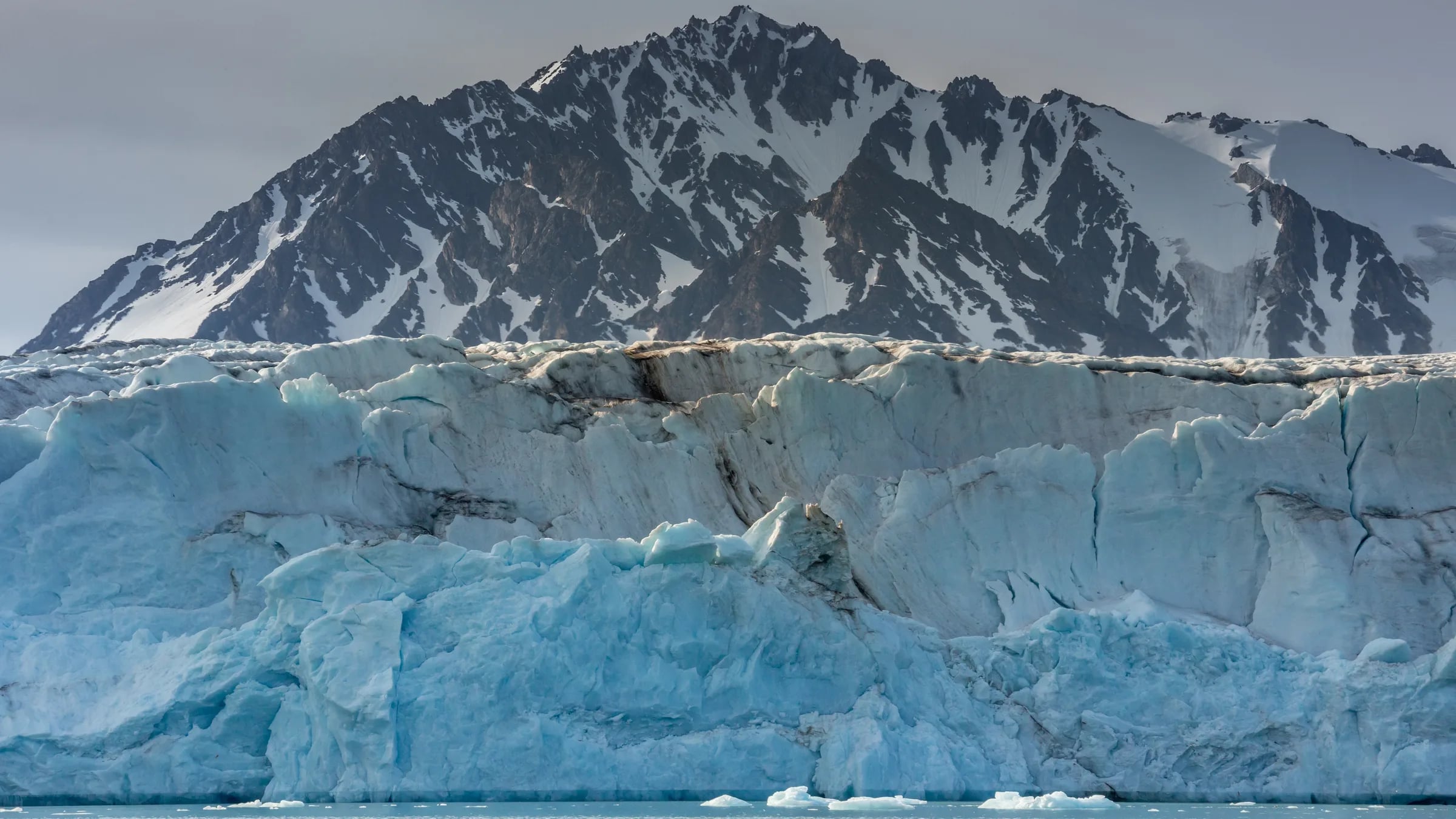 The calving front of the Raudfjordbreen glacier in Spitsbergen, with the mountains of the Northwest Spitsbergen National Park behind it